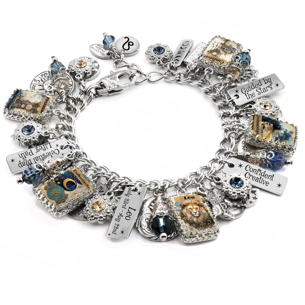 Handcrafted silver charm bracelet inspired by the Leo zodiac sign, featuring celestial and astrological charms including a lion, stars, moons, and engraved tags. Includes vintage-style Leo artwork under glass cabochons, Leo birthdate charm, and sayings like ‘Confident Creative’ and ‘Guided by the Stars’. Embellished with blue and gold Austrian crystals. Displayed on a white background.