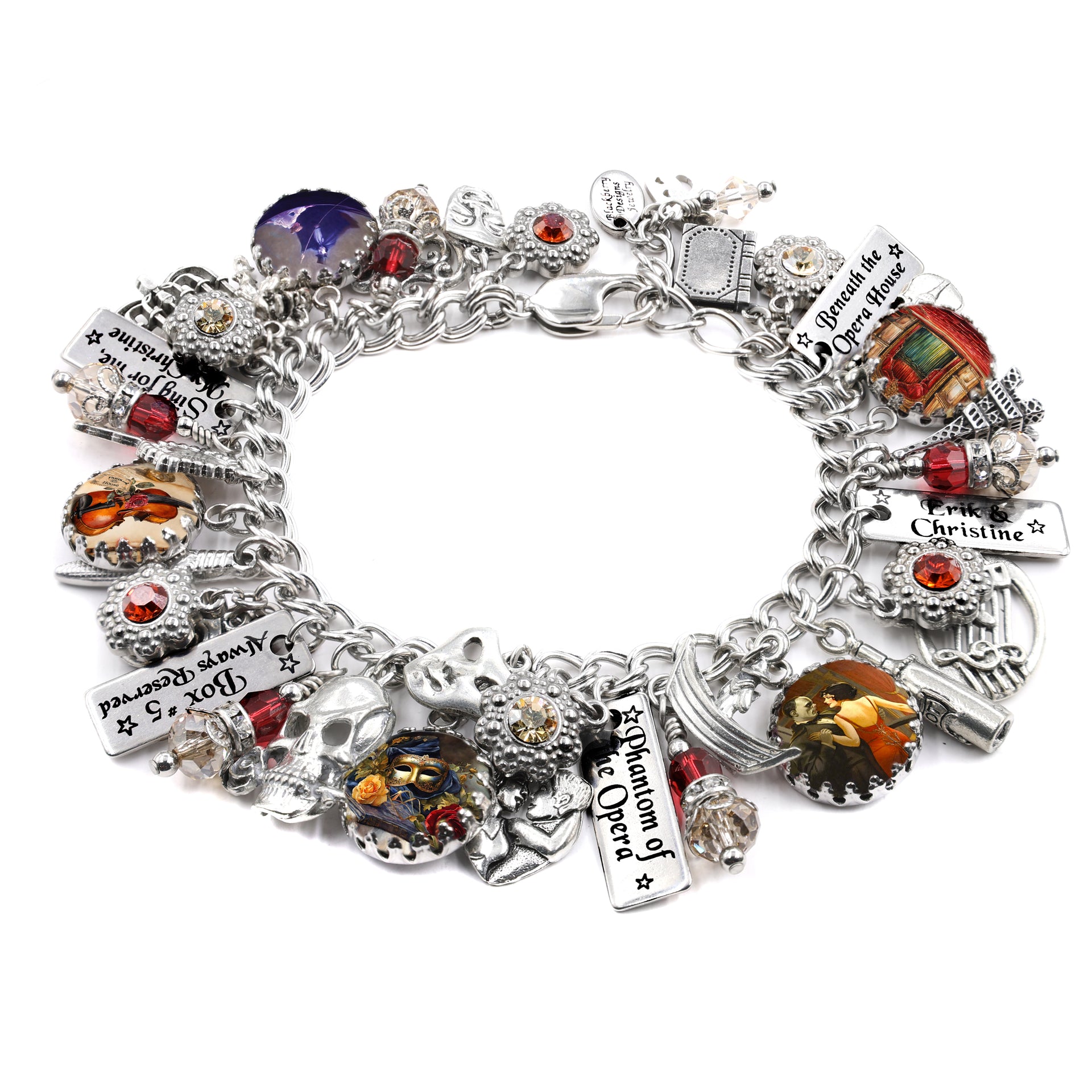 Handcrafted silver charm bracelet inspired by Phantom of the Opera, featuring charms of masks, opera house details, keys, skulls, and artwork of Christine and the Phantom under glass cabochons. Accented with red, clear, and black Austrian crystals and engraved tags like ‘Erik & Christine,’ ‘Box 5 Always Reserved,’ and ‘Beneath the Opera House.’ Displayed on a white background.