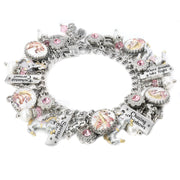 Silver charm bracelet featuring vintage-style pastel carousel horses, sparkling pink crystals, enamel horse charms, and engraved tags with whimsical sayings like âEnchanted Carouselâ and âChasing Rainbows,â displayed on a white background.