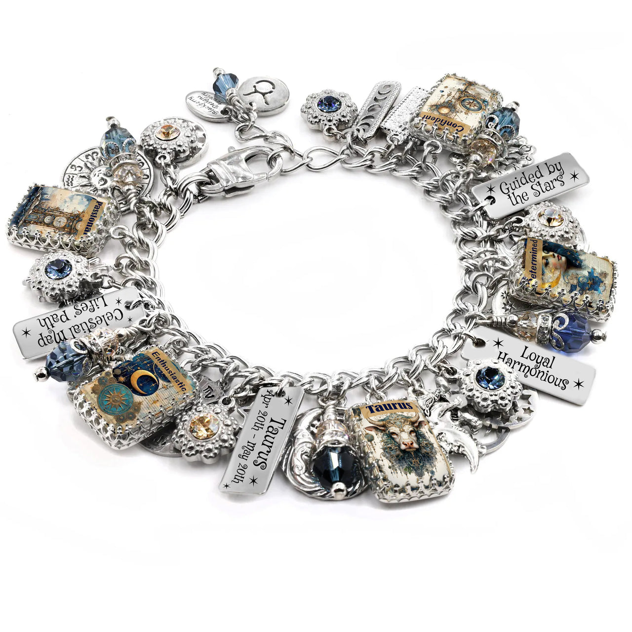 Handcrafted silver charm bracelet inspired by the Taurus zodiac sign, featuring celestial and astrology-themed charms including a bull, moons, stars, and vintage-style Taurus artwork under glass cabochons. Includes engraved charms with zodiac dates and phrases like ‘Loyal Harmonious’ and ‘Guided by the Stars’. Accented with blue and gold Austrian crystals. Displayed on a white background.