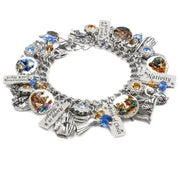 Handcrafted silver charm bracelet featuring a Nativity theme, with intricate charms representing the Birth of Christ, angels, the Holy Family, and traditional symbols like a manger, star, and shepherds. The bracelet includes engraved tags with words like ‘Peace on Earth,’ ‘Nativity,’ ‘Birth of Christ,’ and ‘Angel in a Manger,’ enhanced by sparkling blue and amber Austrian crystals. Captured on a white background, this beautiful bracelet embodies the spirit of Christmas.