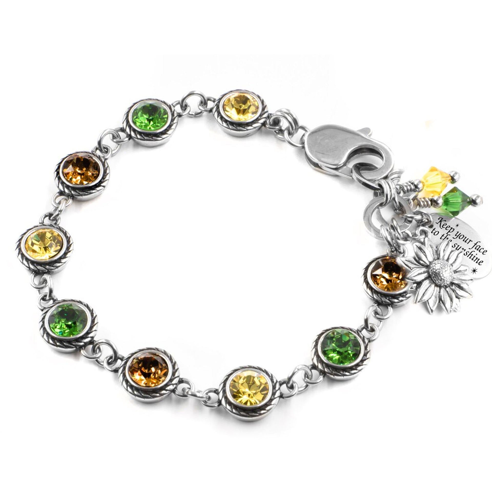 A bracelet with a silver clasp and various colored gemstones, including yellow, green, and orange stones. The bracelet is also adorned with a charm that has a flower design.