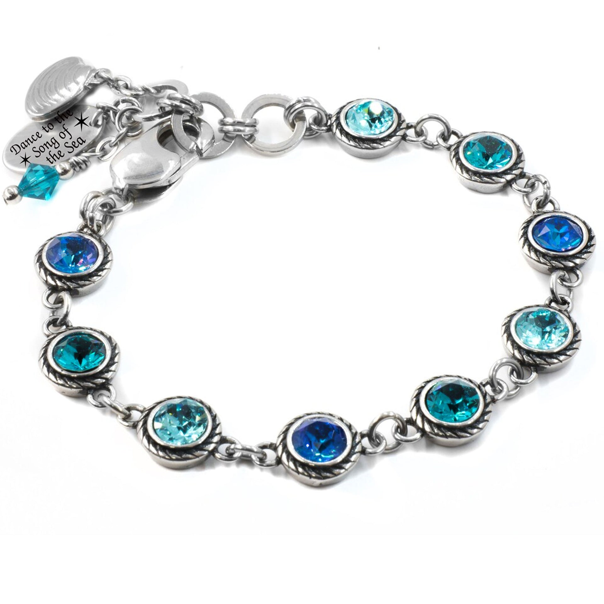 a silver bracelet with austrian crystal in shades of dark blue to light blue, in stainless, non tarnish, with charms of seashell and engraving, dance to the song of the sea
