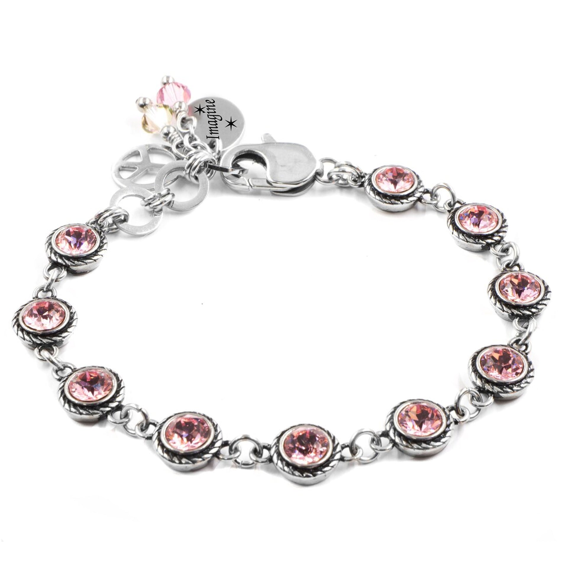 A bracelet with a silver-toned metal design and a charm featuring pink gemstones.