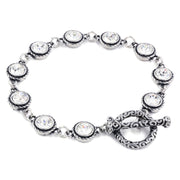 A silver bracelet with a clasp and a row of clear rhinestone stones.