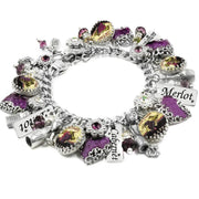 A bracelet adorned with various charms, including a grape, a wine glass, and other decorative elements, as well as charms with the words "Merlot" and "Cabernet".