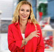 A woman with blonde hair wearing a red blazer and smiling at the camera.
