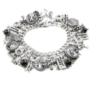 A silver and black charm bracelet with various charms and pendants attached to it.