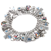 A silver-colored charm bracelet adorned with various charms, including snowmen, bells, and other festive ornaments. The bracelet is decorated with small blue and silver beads, and the charms are arranged in a circular pattern.