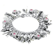 A silver charm bracelet adorned with various charms, including a castle, flowers, and a heart-shaped charm.