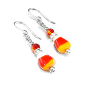 A pair of earrings with candy cane-shaped beads and metal hooks.