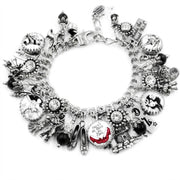 A silver-toned charm bracelet adorned with various charms, including a pair of red shoes, a castle, and other whimsical elements.