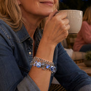 Woman holding a mug outdoors at night with friends in the background