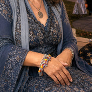 Woman in a blue dress sitting on a porch with Halloween decorations and candy.