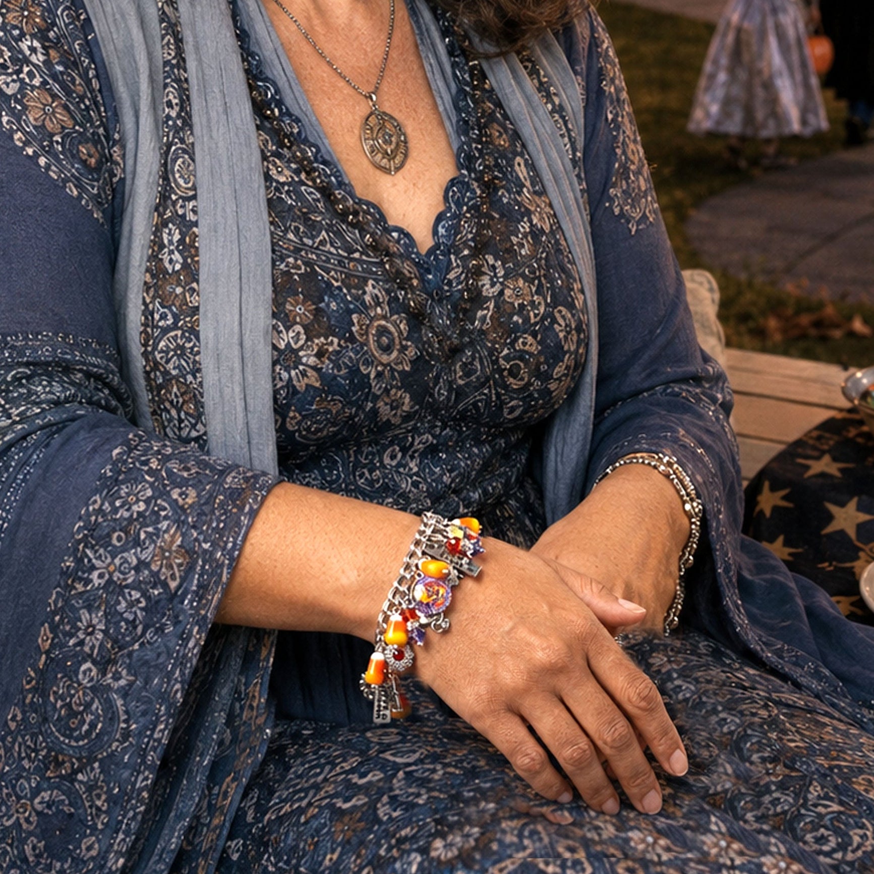 Woman in a blue dress sitting on a porch with Halloween decorations and candy.