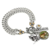 
Handcrafted Cheshire Cat charm bracelet from the Simply Collection featuring artist-designed double curb chain in 316L stainless steel with golden topaz crystal connector ends, ornate filigree toggle clasp, original John Tenniel Cheshire Cat illustration set under glass in scalloped silver cabochon setting, silver tree charm with bird, golden topaz crystal flower connector, and engraved Cheshire Cat bar charm. Handcrafted by artist Dea Shelton, Blackberry Designs Jewelry, California.