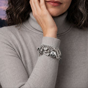 Woman wearing a silver bracelet with a castle and Frankenstein in the background