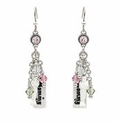 A pair of mummy silver dangle earrings with pink and aurora crystal charms, featuring a small hanging white mummy with black text, shown against a plain white background.