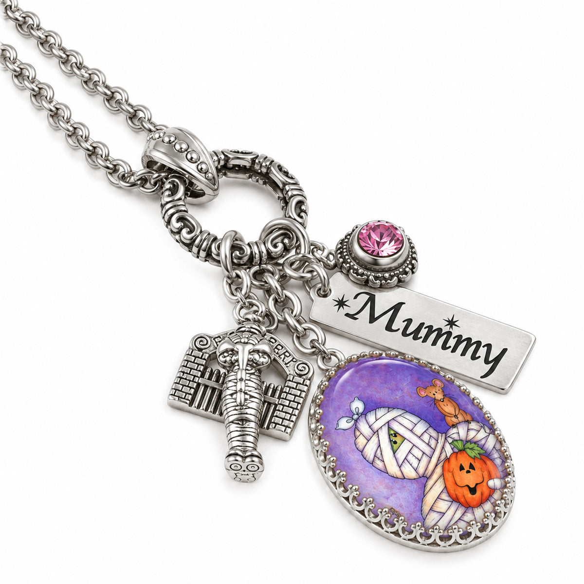 Silver-tone Halloween-themed charm necklace with a 'Mummy' engraved tag, a mummy head charm, a tombstone charm, and an oval pendant featuring a purple mummy wrap background with a jack-o'-lantern and a small giraffe.