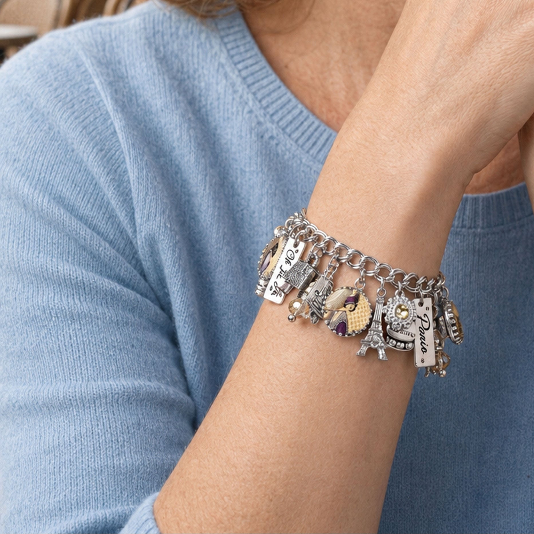 Woman wearing a handcrafted jewelry bracelet with a blurred cityscape background