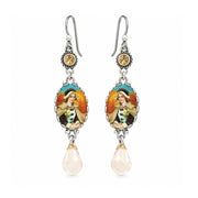 A pair of silver drop earrings featuring oval enamel medallions with a colorful illustration of a woman, accented with a small round gold bead and a dangling faceted pale pink teardrop crystal.