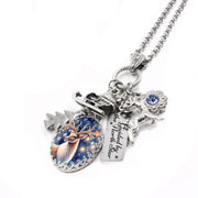 Silver reindeer charm necklace with sleigh, pine tree, and “Guided by the North Star” tag, blue crystal accent, on tarnish-free stainless chain.