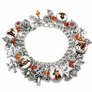 Retro Halloween charm bracelet with orange crystals, vintage pin-up witches in orange and black outfits, and silver engraved star charms.