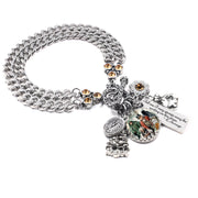 Silver Scrooge charm bracelet with clock, money bag, holly, engraved Dickens quote tag, and topaz crystal accents on stainless chain.