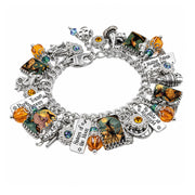 Retro Halloween charm bracelet with 1940s-style witches, teal crystals, black cats, engraved sayings, and glowing crystal pumpkins.