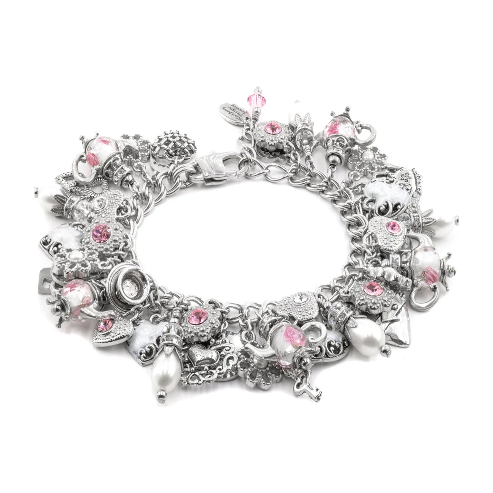 A silver-toned charm bracelet featuring various whimsical charms, including a teapot, skull, crescent moon, and pink gemstone accents, displayed on a clean white background.