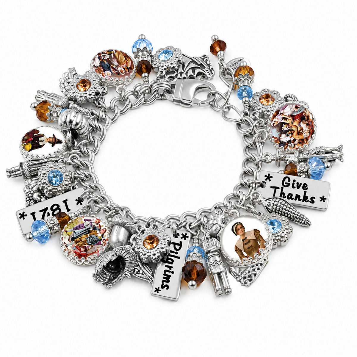 A silver charm bracelet featuring multiple themed charms including a cornucopia, a corn cob with 'Give Thanks' text, a lighthouse charm, a 'Pilgrims' sign, and a '1781' plaque, accented with blue and amber faceted crystals on a white background.