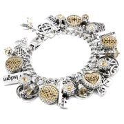 A silver and gold charm bracelet with various charms, including a heart-shaped charm, a crescent moon charm, and other decorative elements.