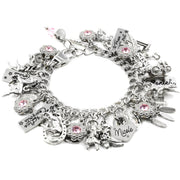 A silver charm bracelet adorned with various charms, including a horse, a bird, and a star, as well as a charm that says "Nicole".