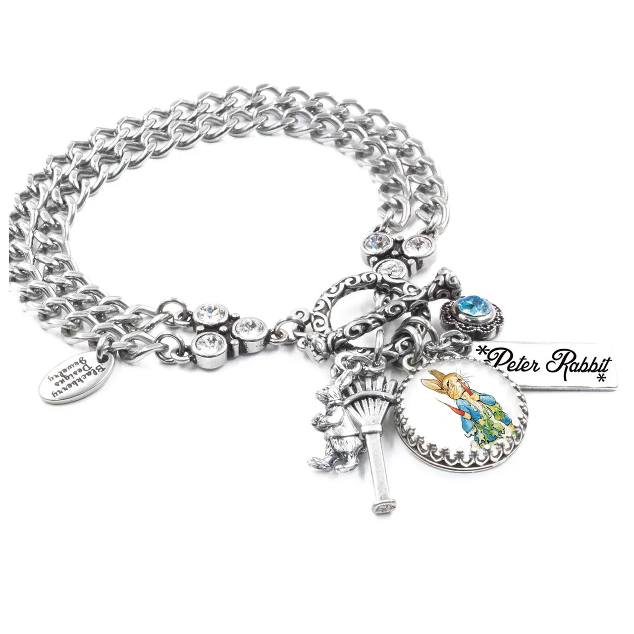 A silver-toned charm bracelet with various charms, including a key, a teddy bear, and a blue gemstone.