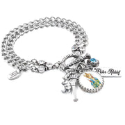 A silver-toned charm bracelet with various charms, including a key, a teddy bear, and a blue gemstone.