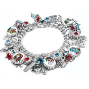 A silver bracelet adorned with various charms, including a skull, flowers, and other decorative elements, as well as charms with the text "Day of the Dead".