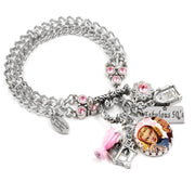 A silver-colored charm bracelet with various charms, including a small pink flower, a small pink cup, and a small pink bird charm. The bracelet also has a charm that says "Fantastic 50's" and a charm that says "Blackberry Design Jewelry".